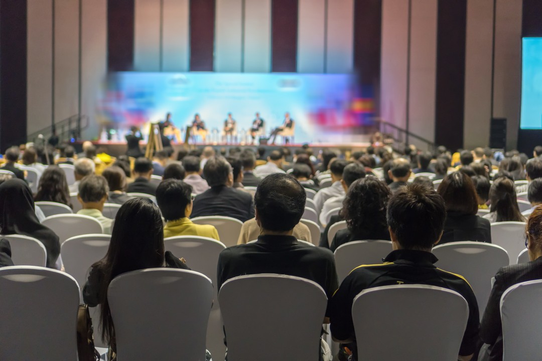 rear-view-audience-listening-speakers-stage-conference-hall-seminar-meeting